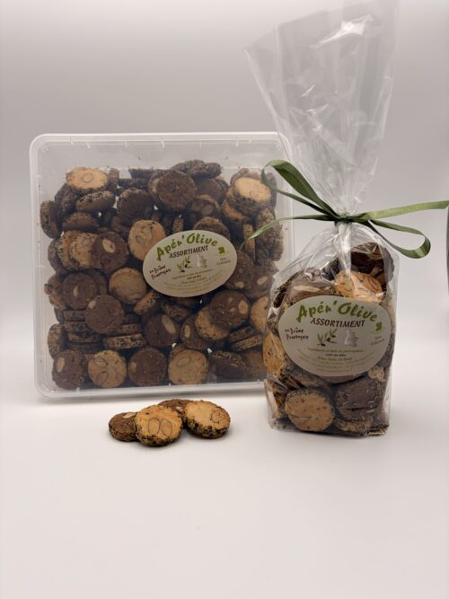 La boîte de 650g et le sachet de 200g des sablés apéritifs Apér'olive Croc'Déli Drôme, avec trois biscuits ronds posés au premier plan révélant de généreuses amandes entières incrustées.