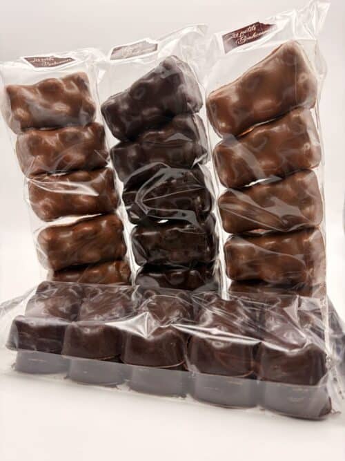 Assortiment d'oursons guimauve en sachets, enrobés de chocolat noir, chocolat au lait et chocolat blanc, accompagné de guimauves enrobées de chocolat noir.