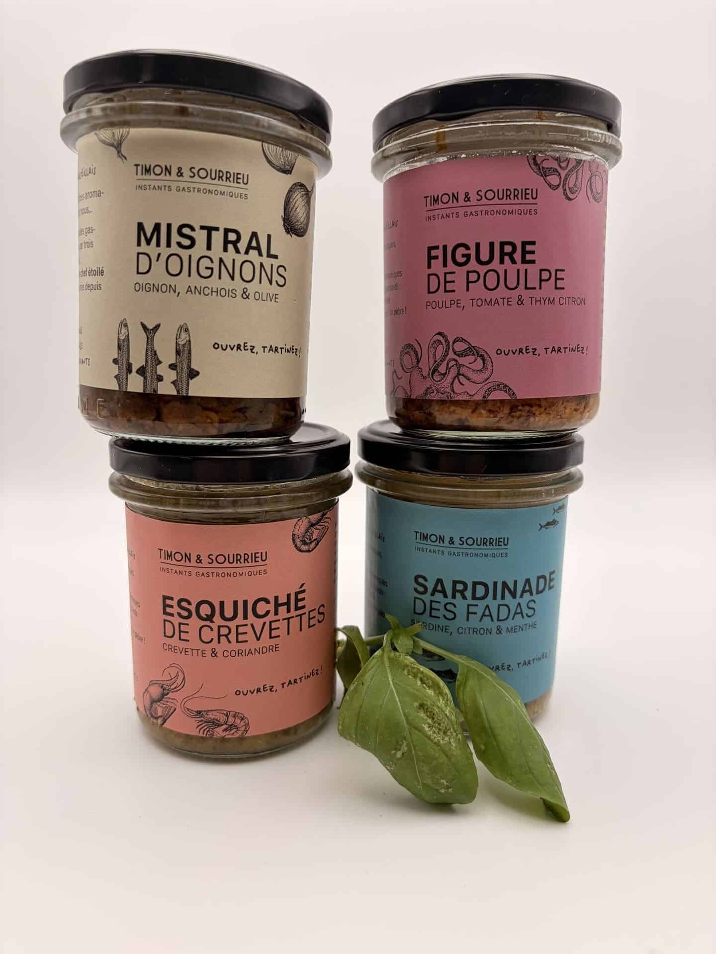 Quatre tartinables artisanaux Timon & Sourrieu présentés en bocaux en verre : Mistral d'oignons, Figure de poulpe, Esquiché de crevettes et Sardinade des Fadas, disposés sur fond blanc avec quelques feuilles de basilic frais.